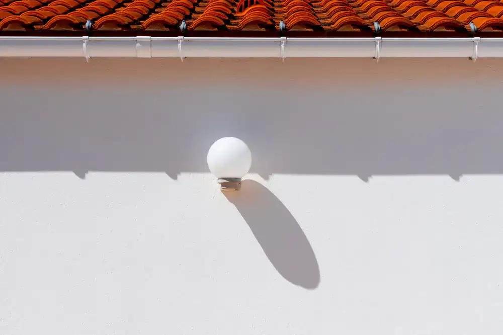 Clearing debris from residential roof gutters